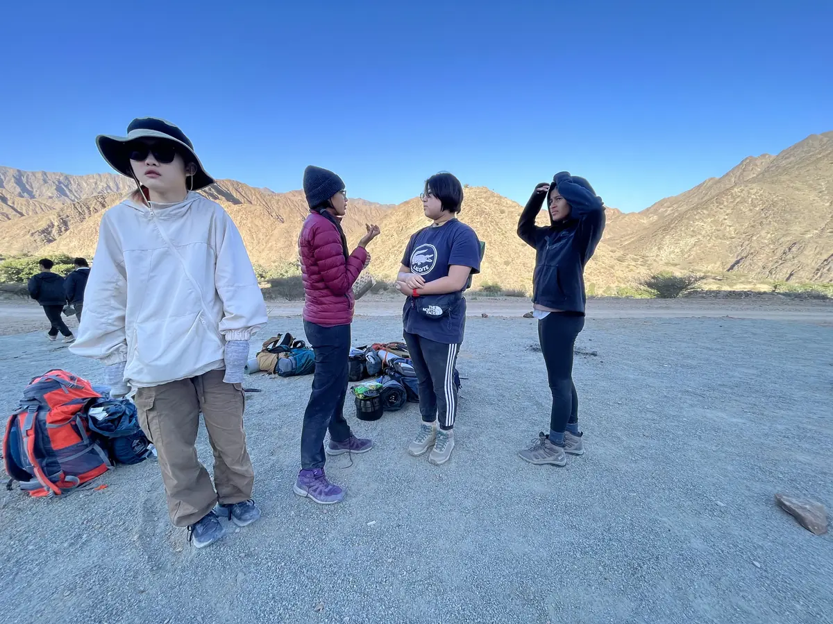 An adult leader talks a group of students through the route before they set off