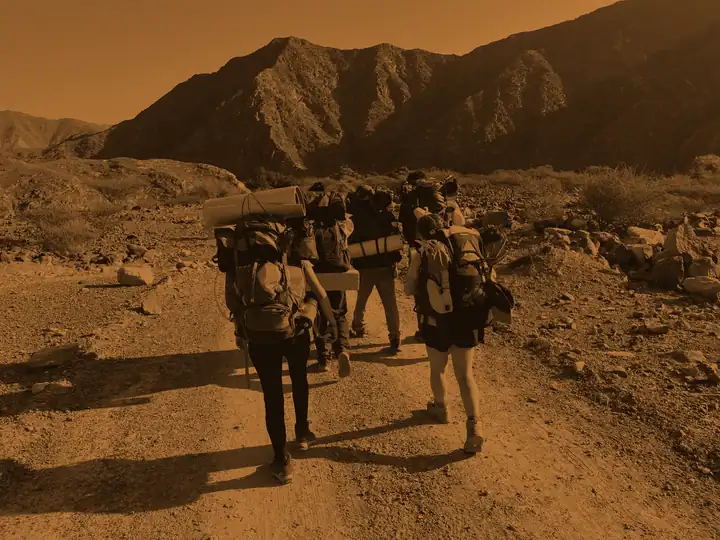 Bronze students walking a wadi floor, washed in bronze